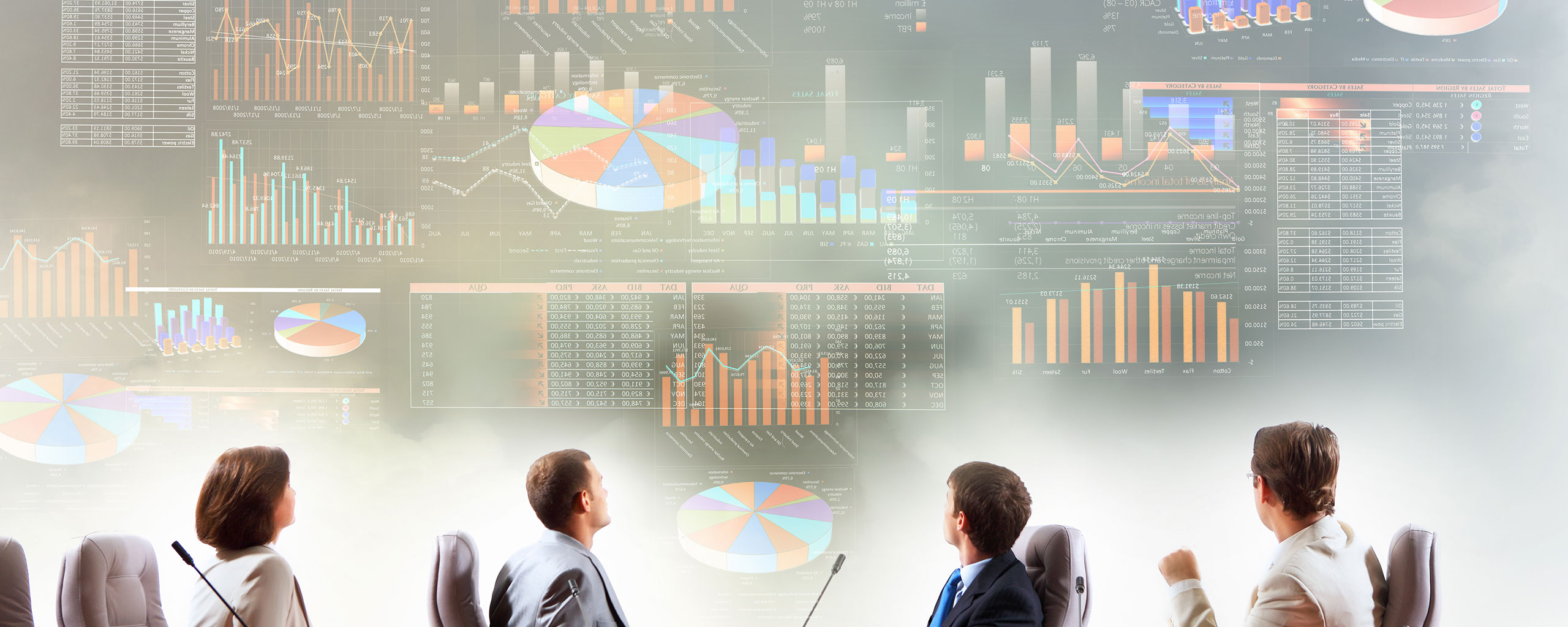 Executivos observando diversos gráficos e indicadores projetados na parede.