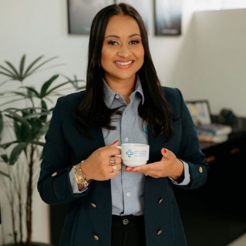 Mulher sorrindo segurando caneca da Mais Contábil em escritório